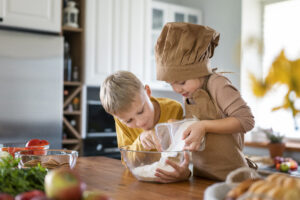 niños divirtiéndose cocinando en casa